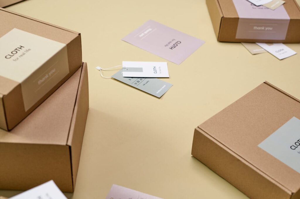 Simple and minimalist cardboard packaging boxes with labels on a yellow surface.